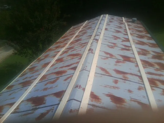 Rusted metal roof panels with new wood purlins before replacement — Storm Damage Roof Repair in Waycross by Roofing Brothers