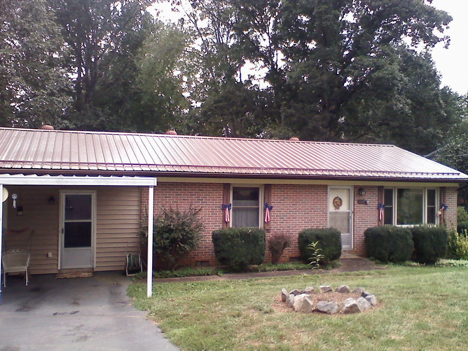 Bronze metal roof and carport on a brick ranch home — Roof Repair work by our crew in Waycross