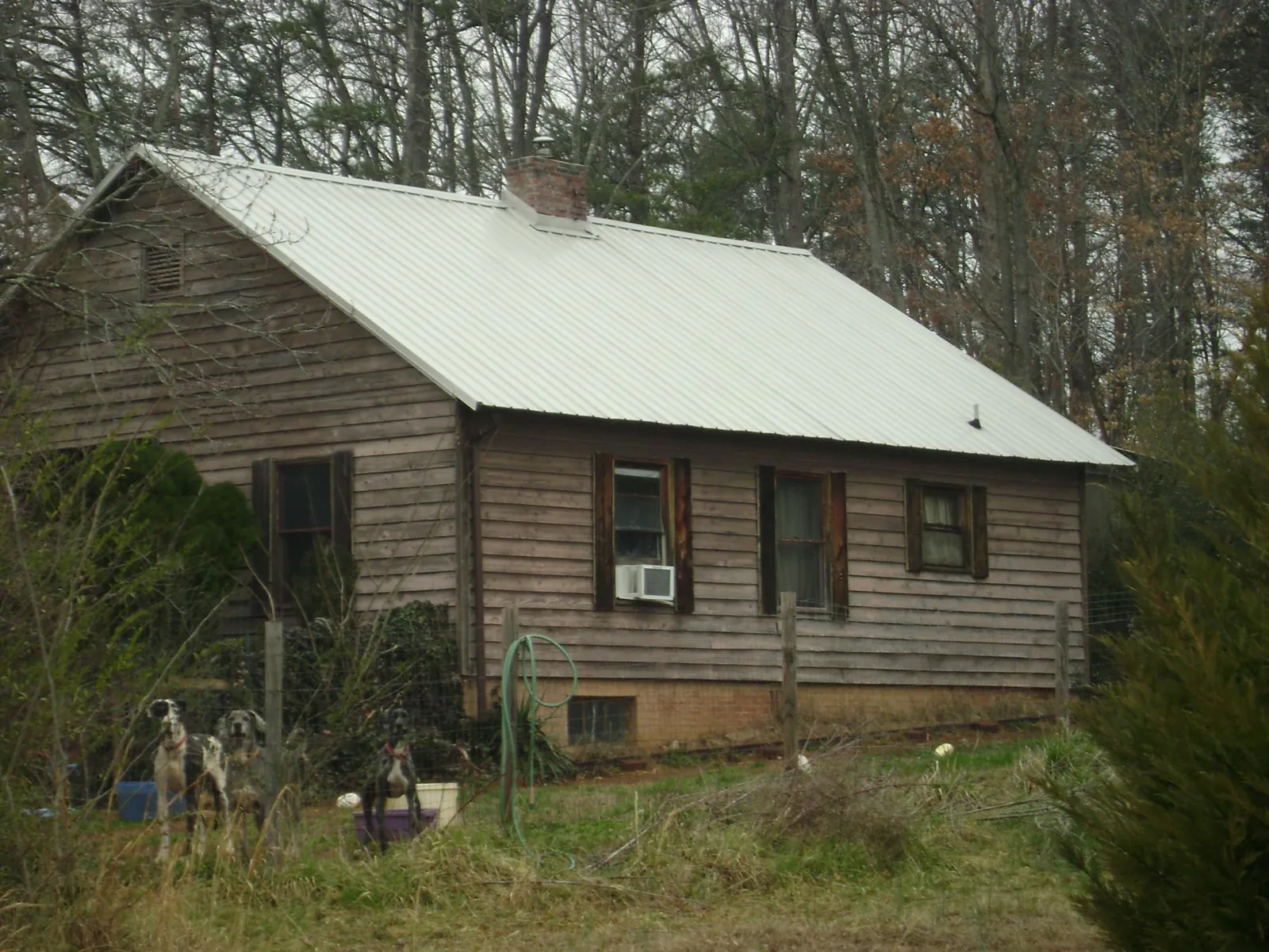 White metal roof on an old wood sided farmhouse, from a Metal Roof Installation job in Waycross